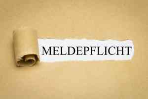 Aufgerissenes Papier mit Aufschrift Meldepflicht